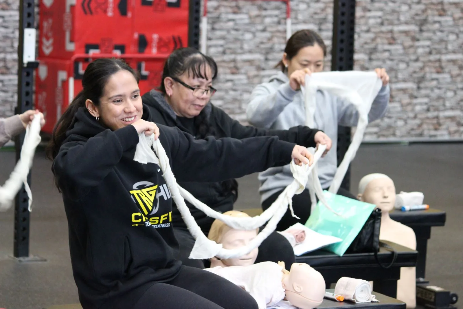 Participants practicing bandaging techniques on training mannequins.