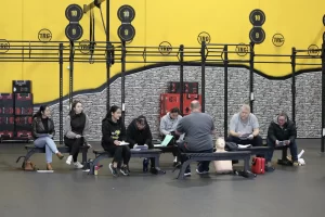 Group of people engaged in a training session at a gym.