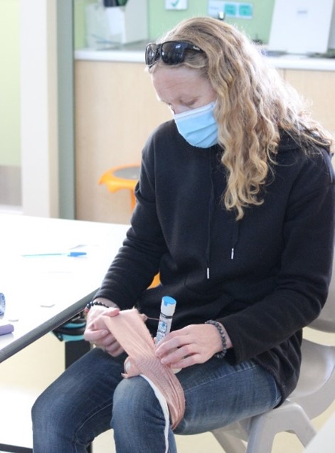 Person applying a bandage while seated at a table.