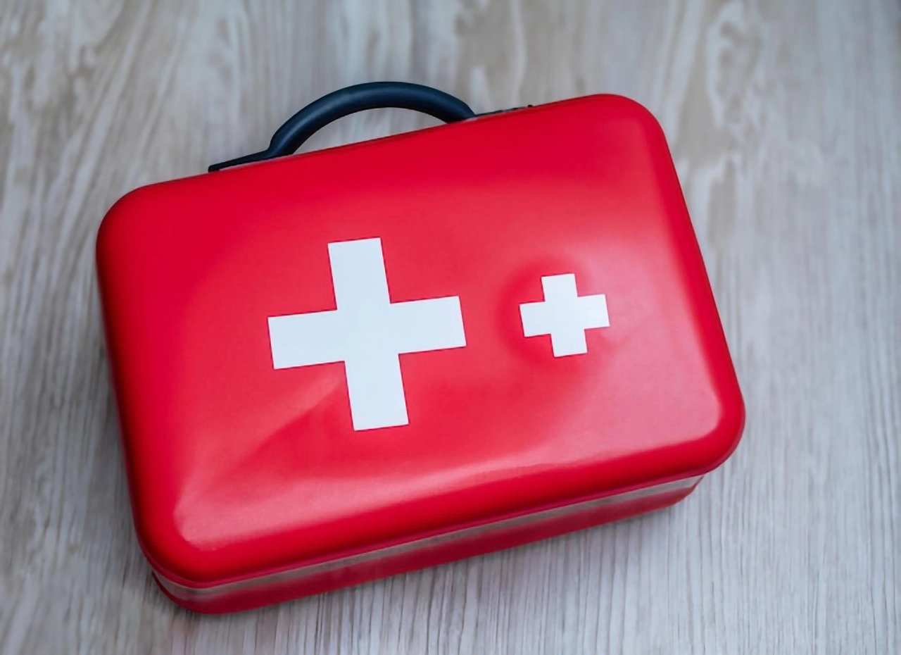 Red first aid kit with white cross symbols on top.
