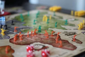 Colorful game pieces on a strategy board map indicating territories.