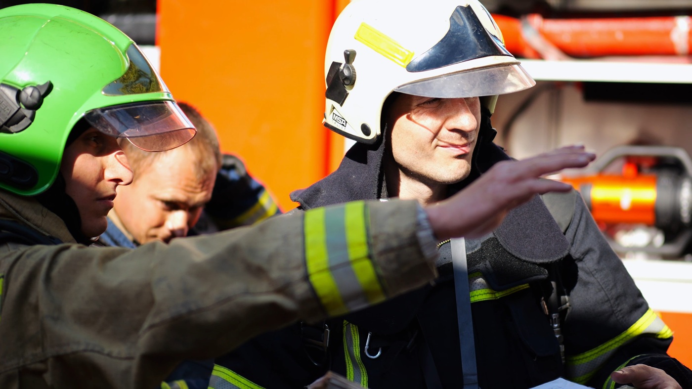Two firefighters discussing strategy during an emergency situation.