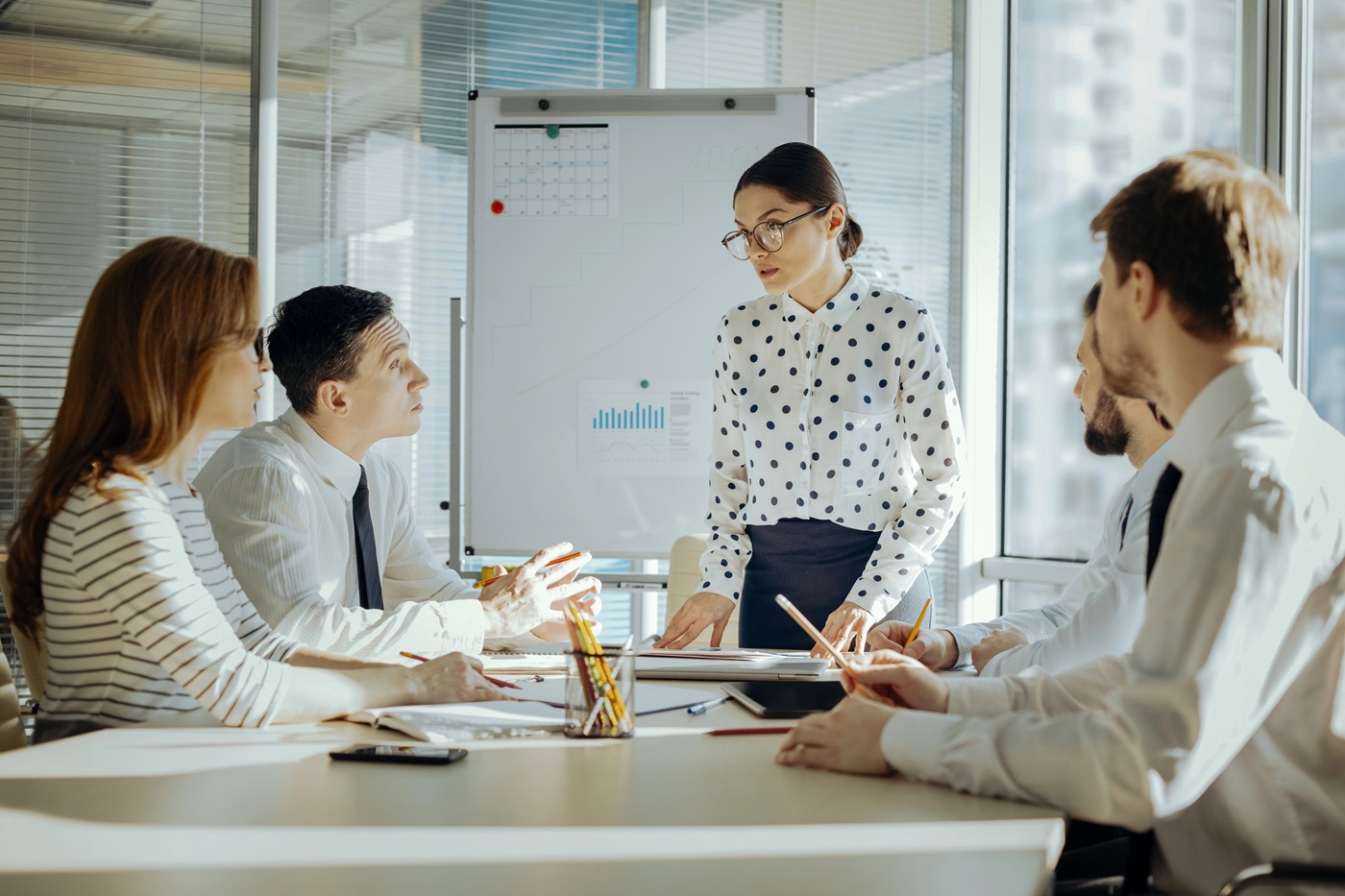 A woman presents to a group during a business meeting.