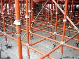 Complex arrangement of orange scaffolding pipes on a construction site.