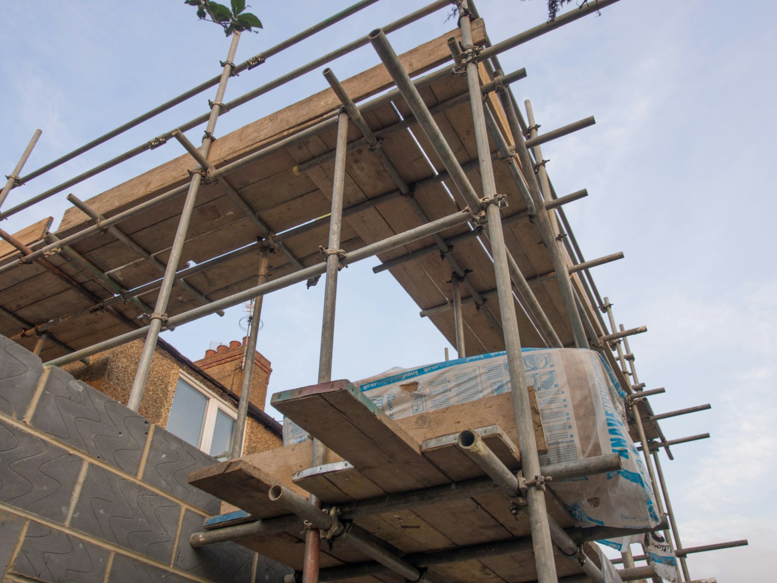 Residential construction site with building materials and limited working space around the job.